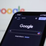 Logo Google affiché sur un smartphone après l’amende de 890 millions d’euros infligée par l’Union européenne