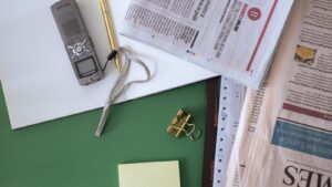 Journaux, carnet et dictaphone illustrant la reprise du Journal des Entreprises par Overlord
