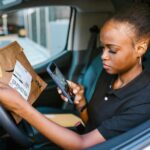 Professionnelle contrôlant un colis de commerce électronique avec un smartphone
