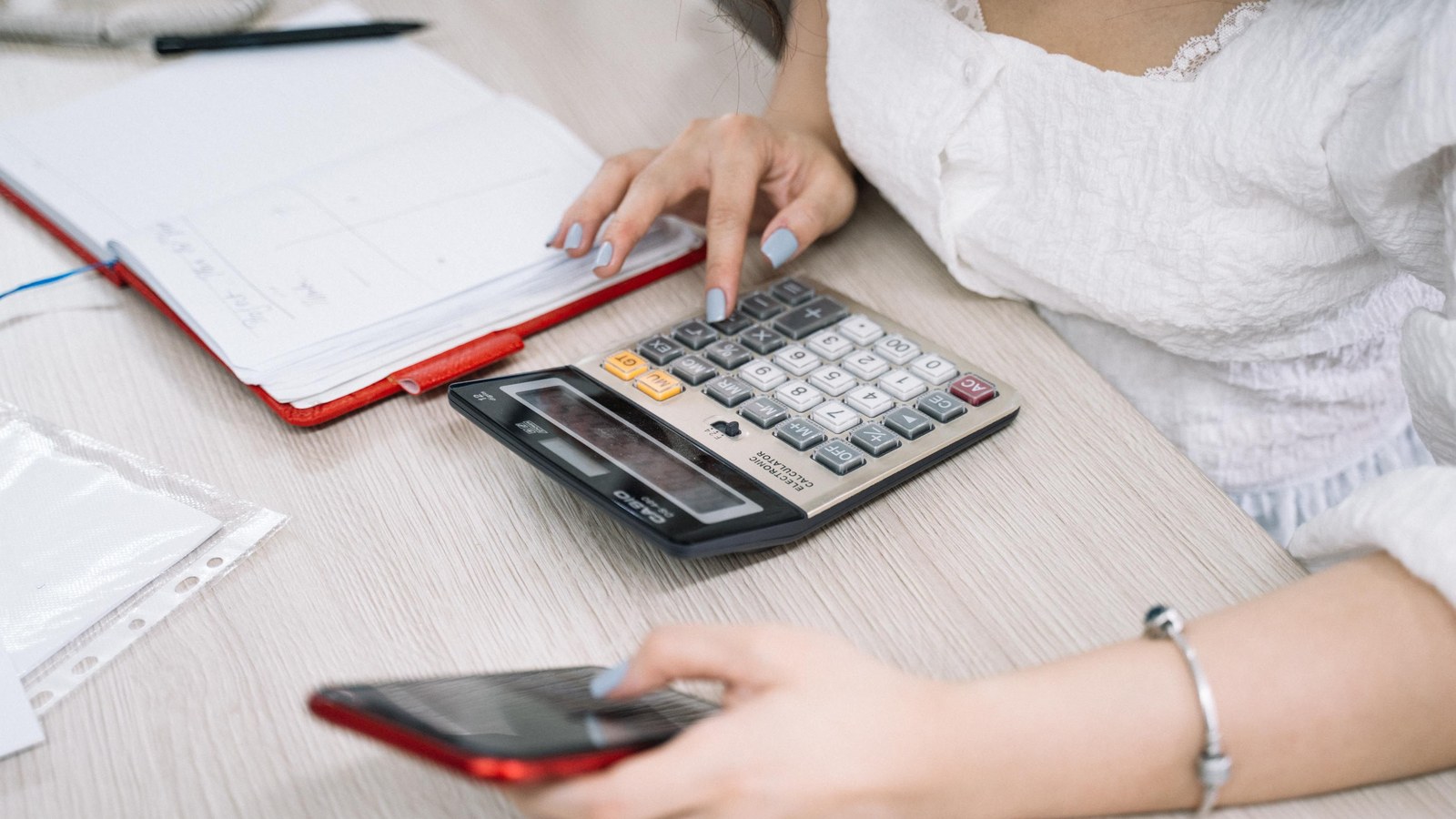 Personne calculant son budget face aux changements du 1er août 2026