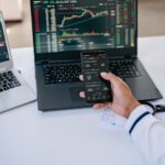 Investisseur consultant des ETF et les marchés financiers sur son smartphone et son ordinateur
