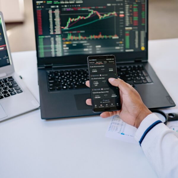 Investisseur consultant des ETF et les marchés financiers sur son smartphone et son ordinateur