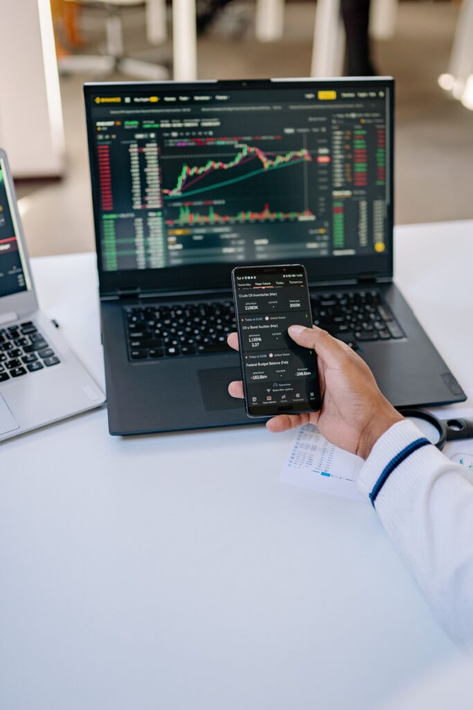 Investisseur consultant des ETF et les marchés financiers sur son smartphone et son ordinateur