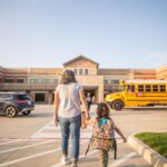 Parent accompagnant son enfant à l’école lors de la rentrée scolaire avant d’aller travailler