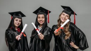 Trois jeunes diplômées présentant leur diplôme avant leur entrée sur le marché du travail