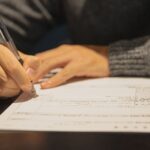 Fraude aux allocations à Nantes : une personne remplit un document administratif, photo d’illustration