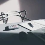 IA en direction financière : ordinateur et calculatrice sur un bureau, illustration du suivi des coûts
