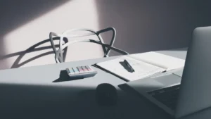 IA en direction financière : ordinateur et calculatrice sur un bureau, illustration du suivi des coûts