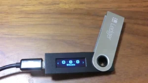 Portefeuille matériel Ledger Nano S connecté par USB, utilisé en illustration des agressions crypto.