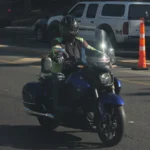 Motard casqué sur une Honda Valkyrie bleue dans la circulation.