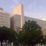 Siège de la Banque mondiale à Washington, avec sa façade vitrée et des arbres au premier plan.