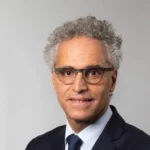 Portrait de Bernard Cohen-Hadad en costume sombre et cravate, devant un fond gris.