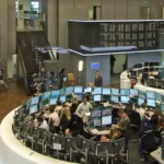 Opérateurs devant des écrans de cotation et tableaux de cours sur le parquet de la Bourse de Francfort.