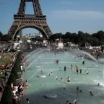 Des personnes dans les fontaines du Trocadéro à Paris, devant la tour Eiffel.