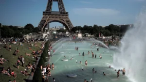 Des personnes dans les fontaines du Trocadéro à Paris, devant la tour Eiffel.