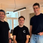 Trois personnes, deux debout et une assise, dans des bureaux sur une photo transmise par Cleavr.