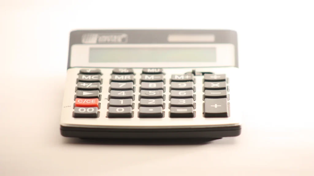 Calculatrice électronique à touches noires sur un fond clair.