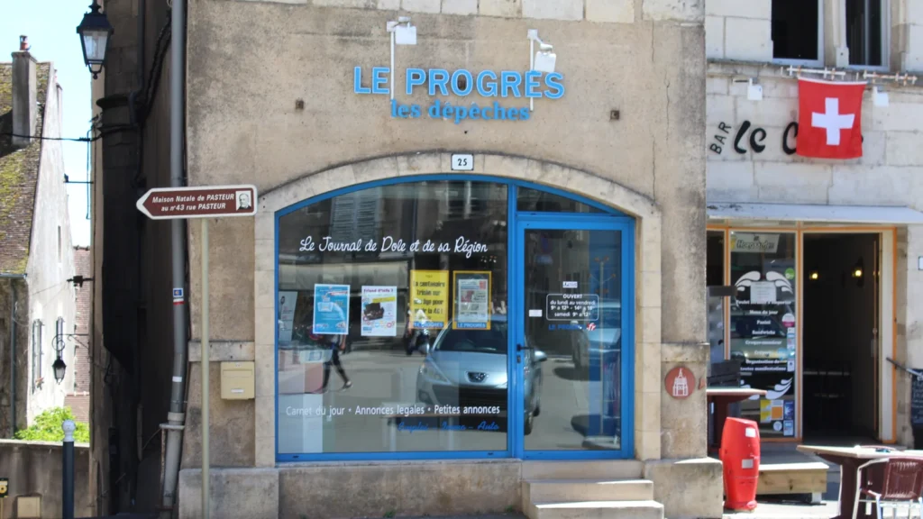 Façade du bureau du Progrès – Les Dépêches à Dole, avec son enseigne bleue et sa vitrine.