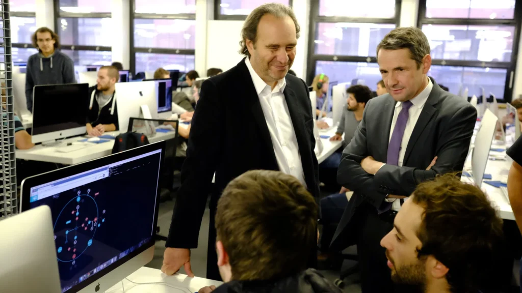 Xavier Niel et Thierry Mandon devant des étudiants et des ordinateurs dans une salle de l’école 42.