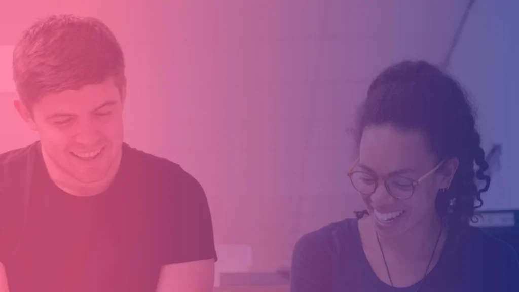 Un homme et une femme regardent vers un plan de travail, sous un dégradé rose et bleu.
