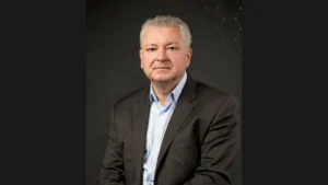 Frédéric Lagante, en veste sombre et chemise claire, photographié sur fond sombre.