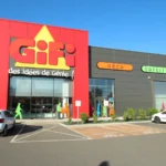 Façade du magasin GiFi de Coignières, avec son enseigne rouge et jaune et des voitures sur le parking.