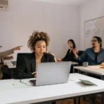 Une équipe équipée de casques-micro travaille sur des ordinateurs portables dans un bureau.