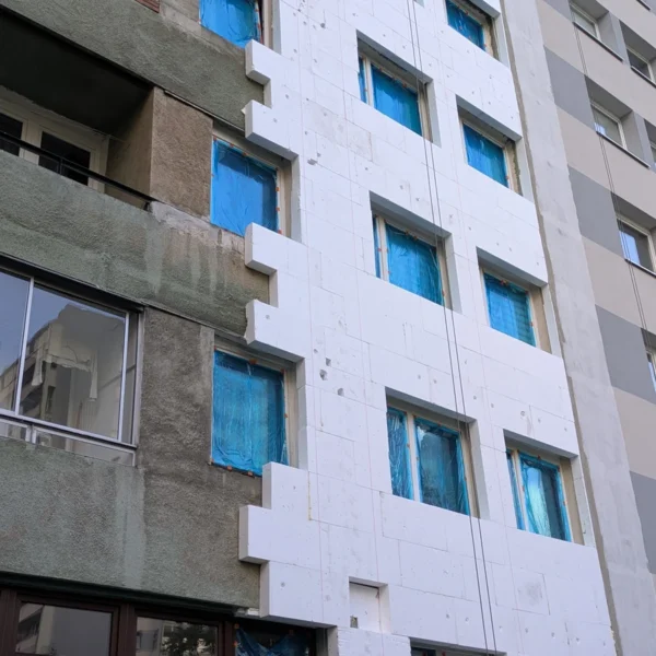Panneaux d’isolation extérieure en cours de pose sur la façade d’un immeuble à Varsovie.