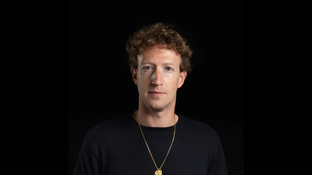 Mark Zuckerberg, dirigeant de Meta, en pull sombre devant un fond noir.