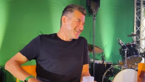 Matthieu Pigasse assis dans un fauteuil orange devant une batterie aux JDE 2026.