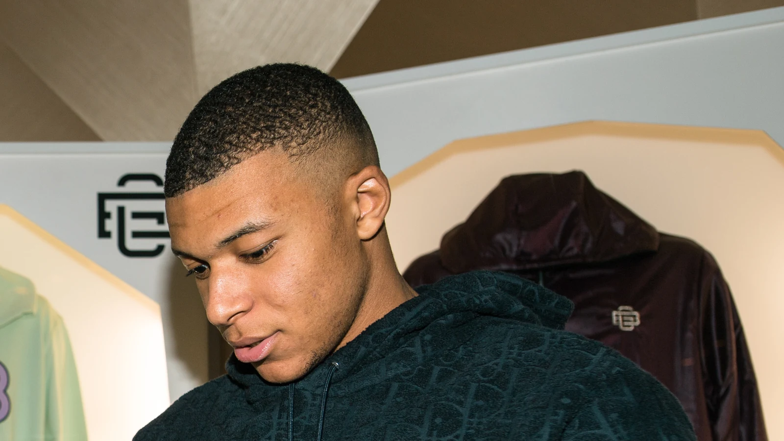 Portrait de Kylian Mbappé portant une veste sombre.