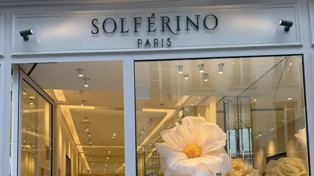 La devanture de la boutique Solférino Paris, avec sa porte ouverte et sa vitrine fleurie.