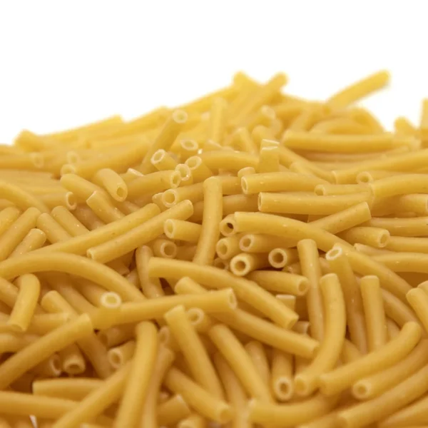 Un tas de macaronis secs jaunes sur fond blanc.