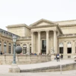 Façade du palais Bourbon et cour intérieure, avec des visiteurs devant les colonnes.