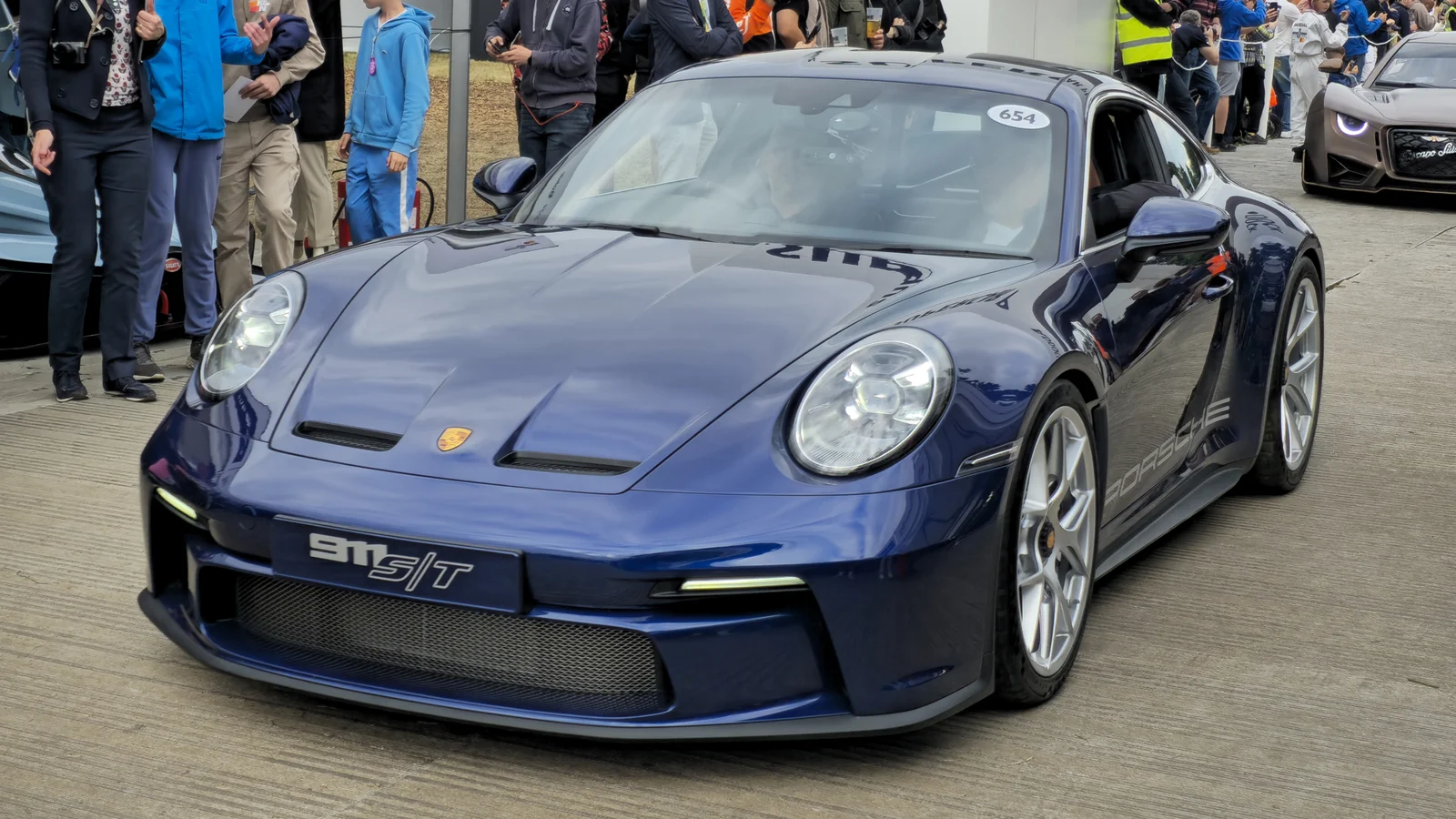 Porsche 911 S/T bleue vue de trois quarts avant, entourée de visiteurs