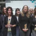 Trois femmes tenant un trophée au premier plan, entourées d’autres participants au Prix des dirigeantes de l’ESS.