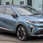 Renault Symbioz bleu vu de trois quarts avant devant une concession.