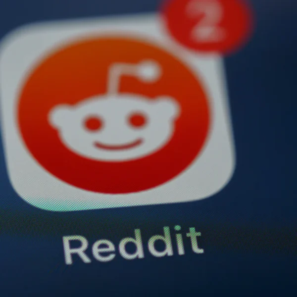 Gros plan de l’icône orange et blanche de Reddit sur un écran, avec le nom de l’application.