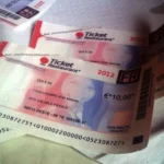 Plusieurs titres Ticket Restaurant papier de 10 euros, millésimés 2012, posés sur une table.