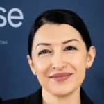 Samira Belkacem devant un panneau portant le logo GSE.
