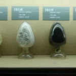 Échantillons d’oxydes de terres rares dans quatre récipients en verre, présentés sous leurs étiquettes.