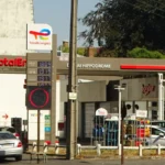 Une station-service TotalEnergies à Douai, avec son enseigne, ses pompes et plusieurs voitures.