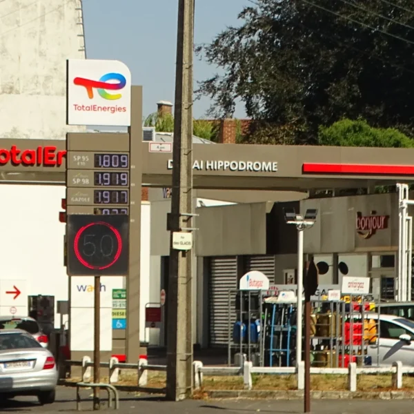 Une station-service TotalEnergies à Douai, avec son enseigne, ses pompes et plusieurs voitures.