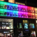 Façade vitrée du magasin Uniqlo de Chicago éclairée de nuit, avec ses enseignes rouges.