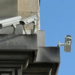 Trois caméras de vidéosurveillance fixées sur une façade en pierre, quai des Orfèvres à Paris.