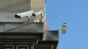 Trois caméras de vidéosurveillance fixées sur une façade en pierre, quai des Orfèvres à Paris.
