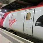 Ancienne rame Pendolino de Virgin Trains en gare, avec son logo rouge sur une livrée argentée.