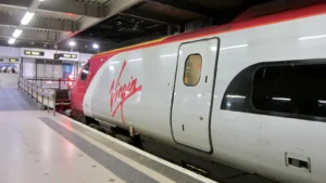 Ancienne rame Pendolino de Virgin Trains en gare, avec son logo rouge sur une livrée argentée.