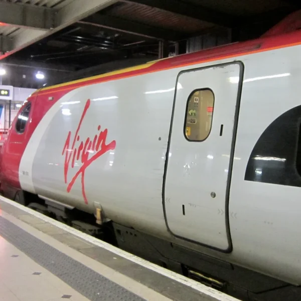 Ancienne rame Pendolino de Virgin Trains en gare, avec son logo rouge sur une livrée argentée.