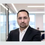 Yaz Bekkar, en veste sombre et chemise blanche, photographié dans des bureaux.